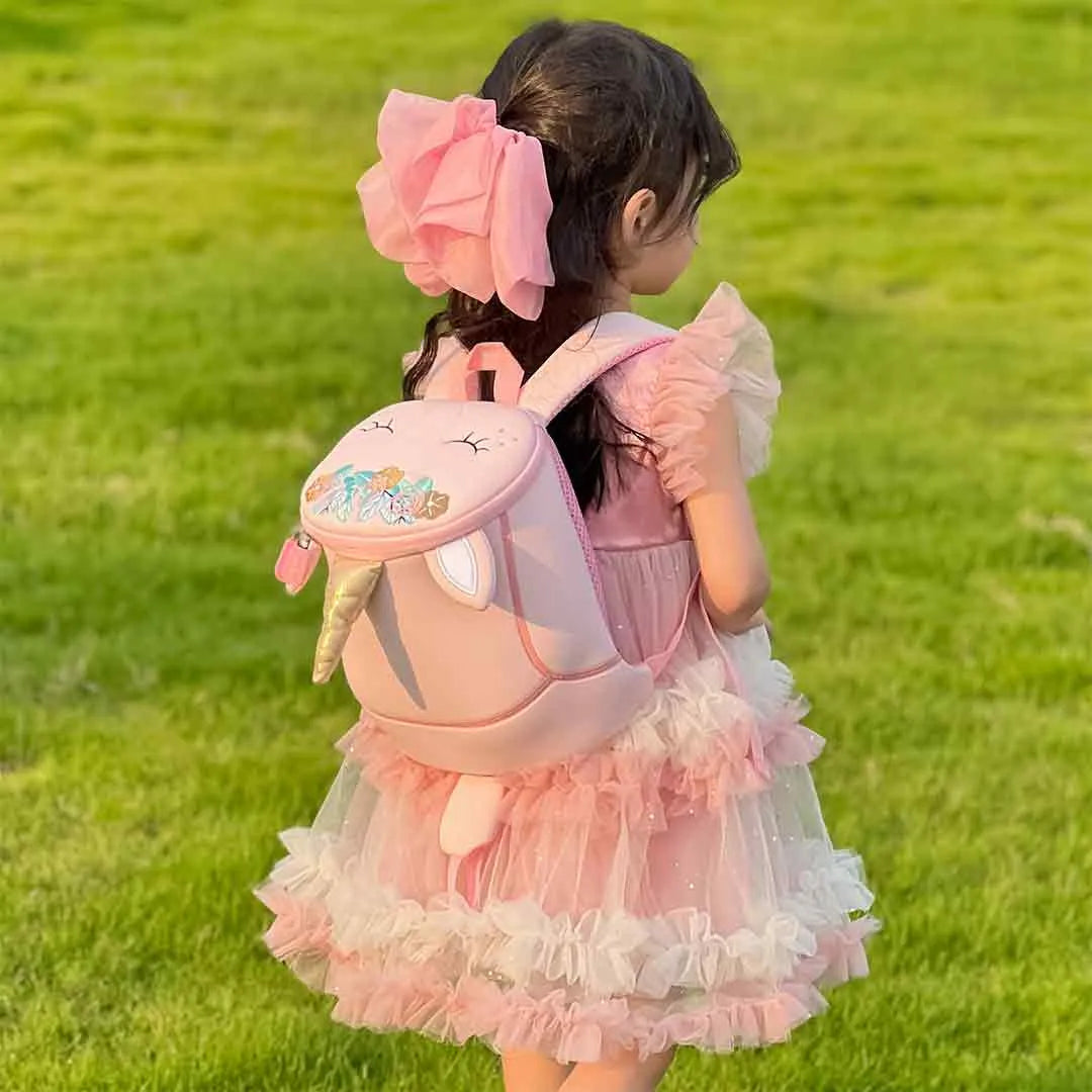 Close-up of girl wearing the pink unicorn crossbody bag with zip closure and magical horn detail