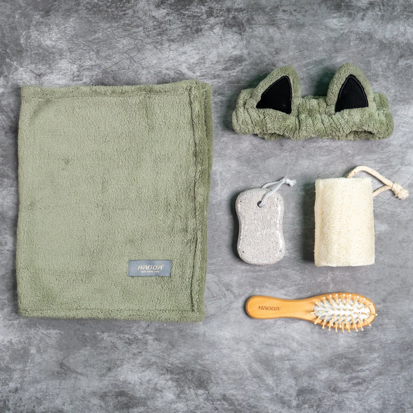 Olive green towel and headband set with wooden brush and bath tools.