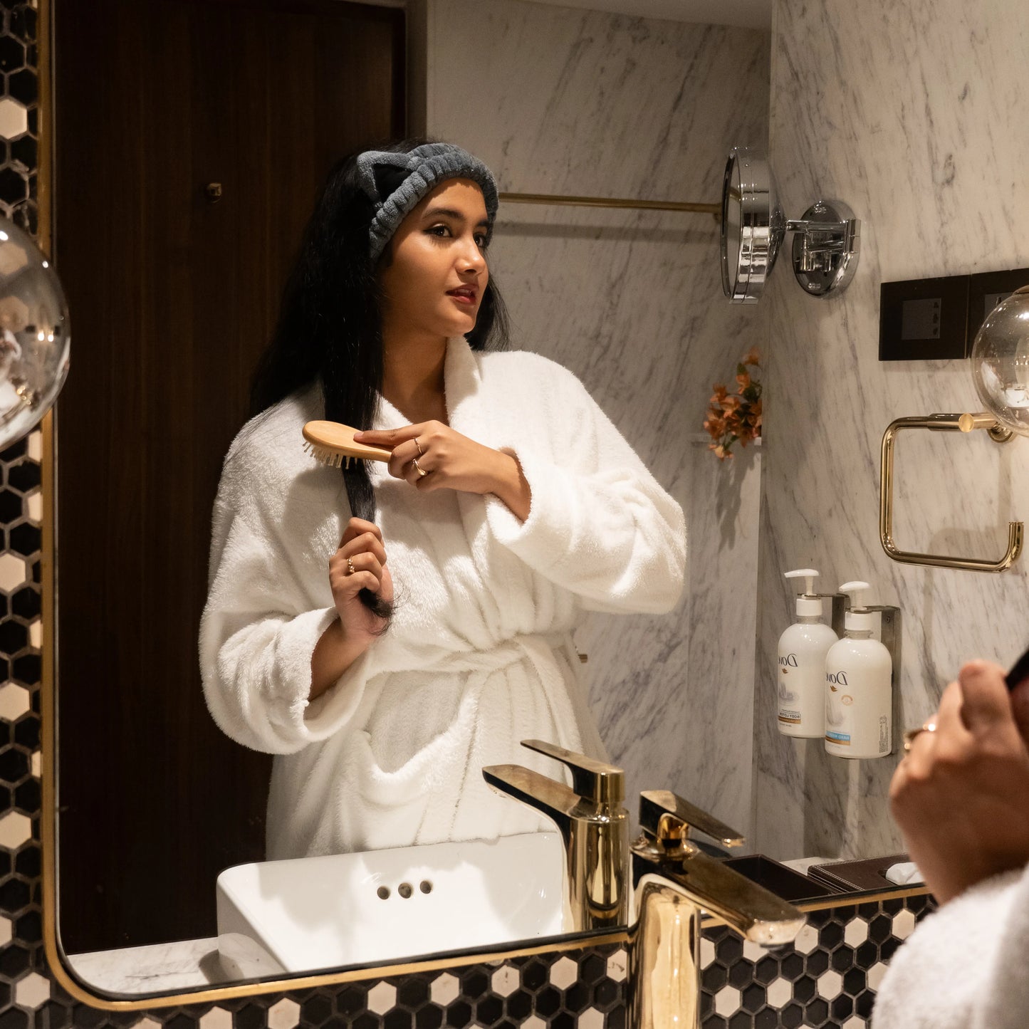 Woman using Kitty Bloom combo set in a bathroom mirror scene.
