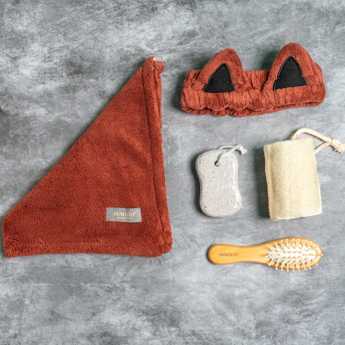 Maroon combo set arranged with pumice stone and loofah for spa use.