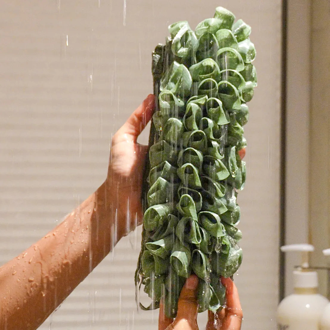 Glow loop held by a person with water falling on it in the shower.