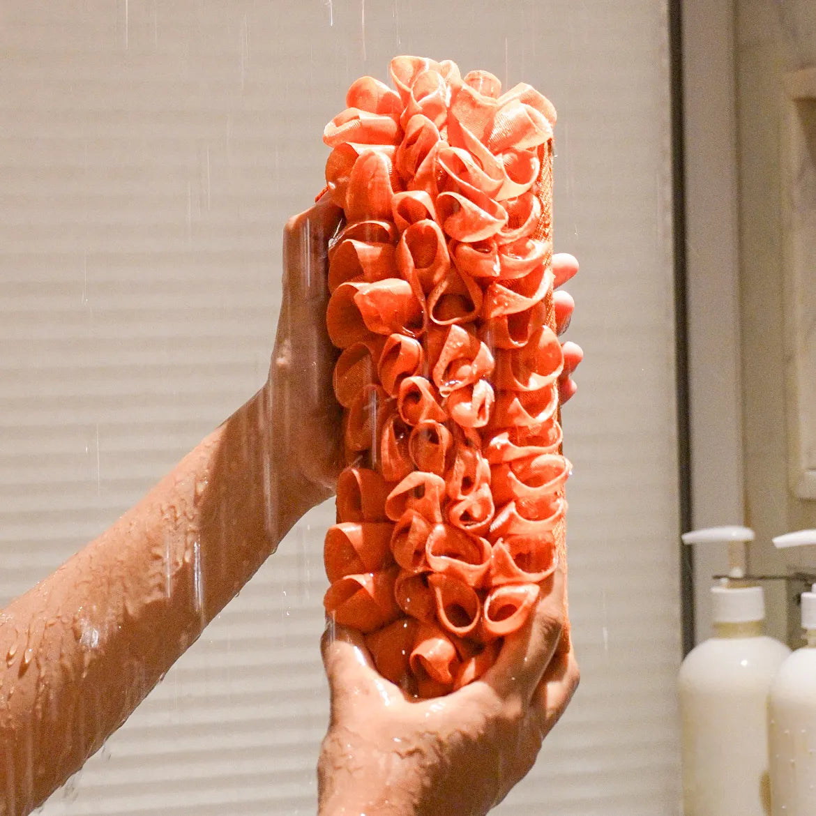 Glow loop held by a person with water falling on it in the shower.