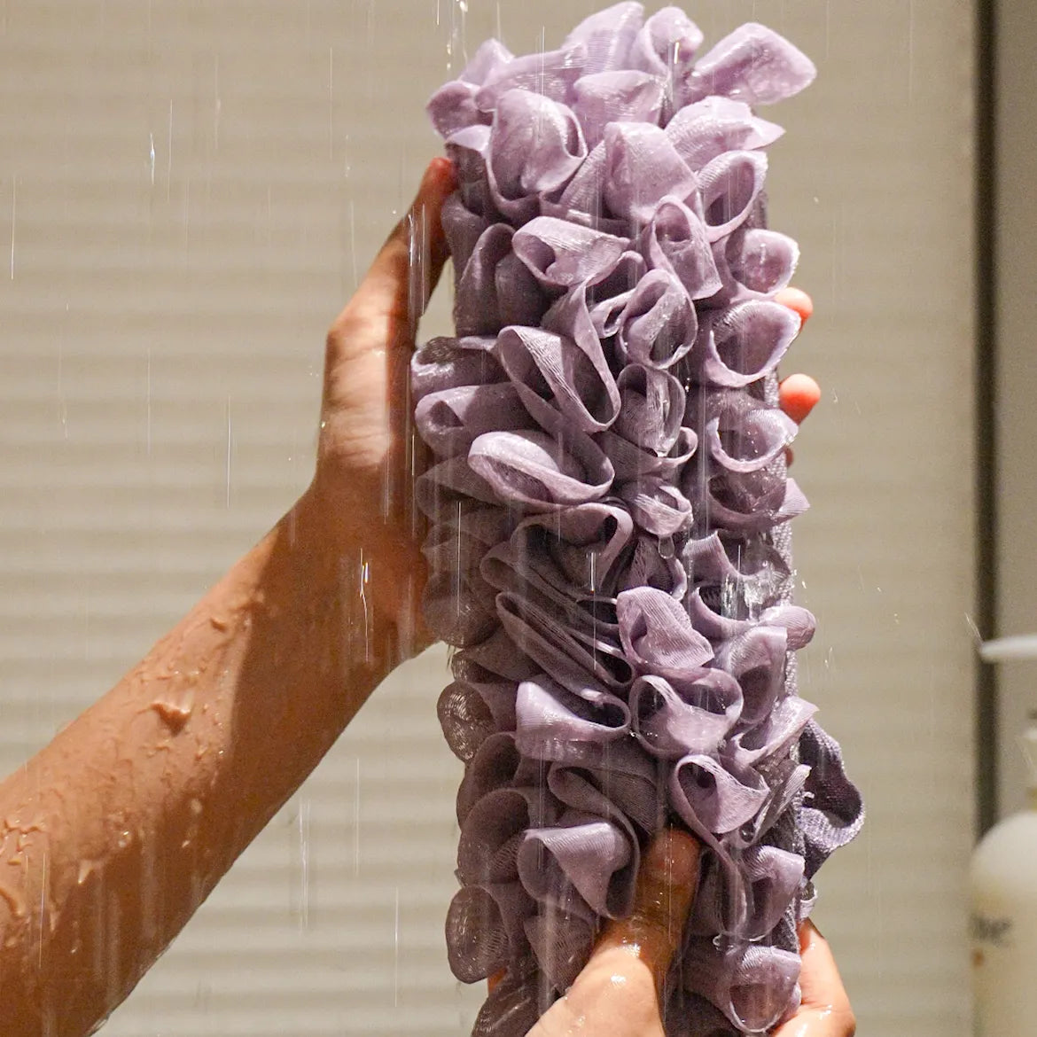 Glow loop held by a person with water falling on it in the shower.