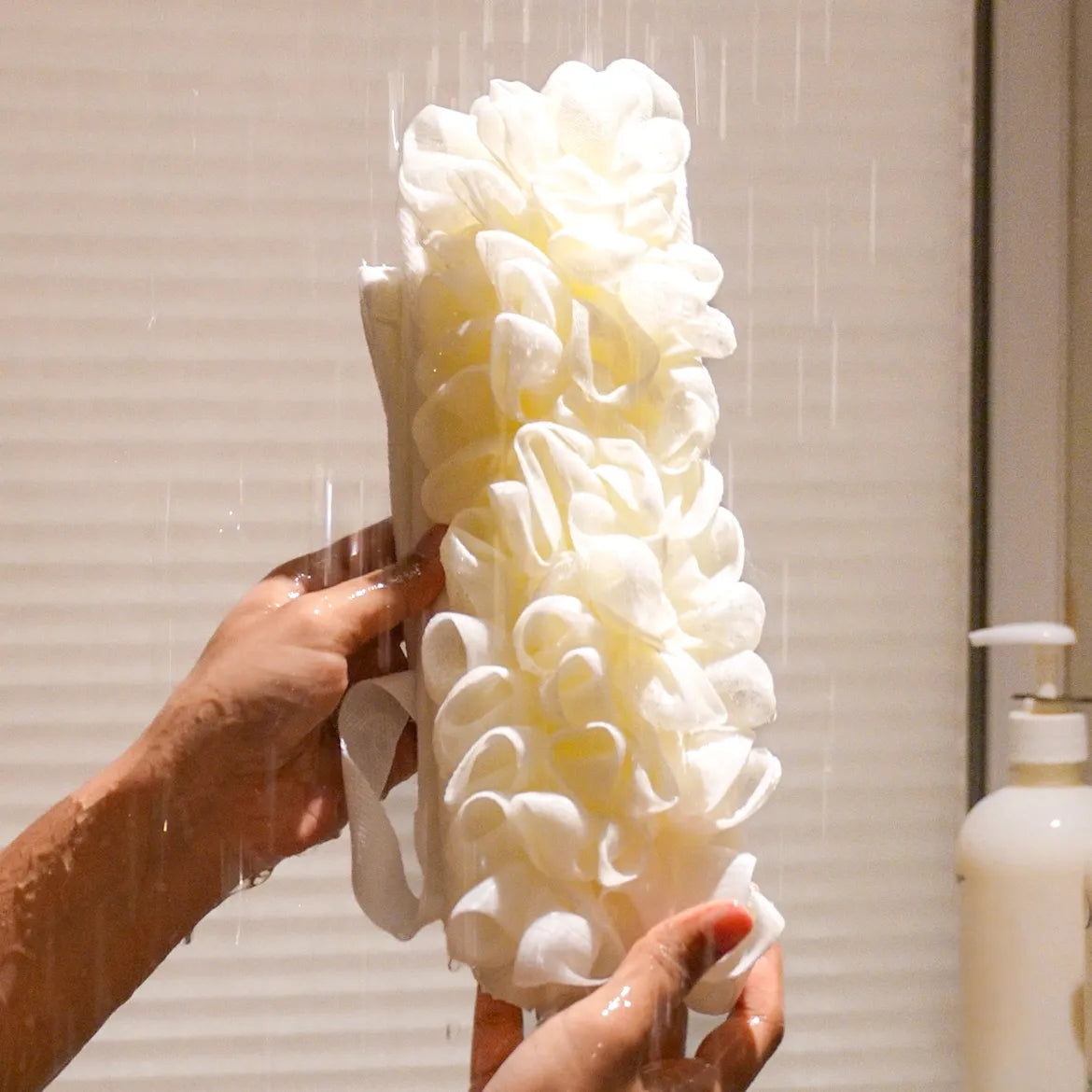 Glow loop held by a person with water falling on it in the shower