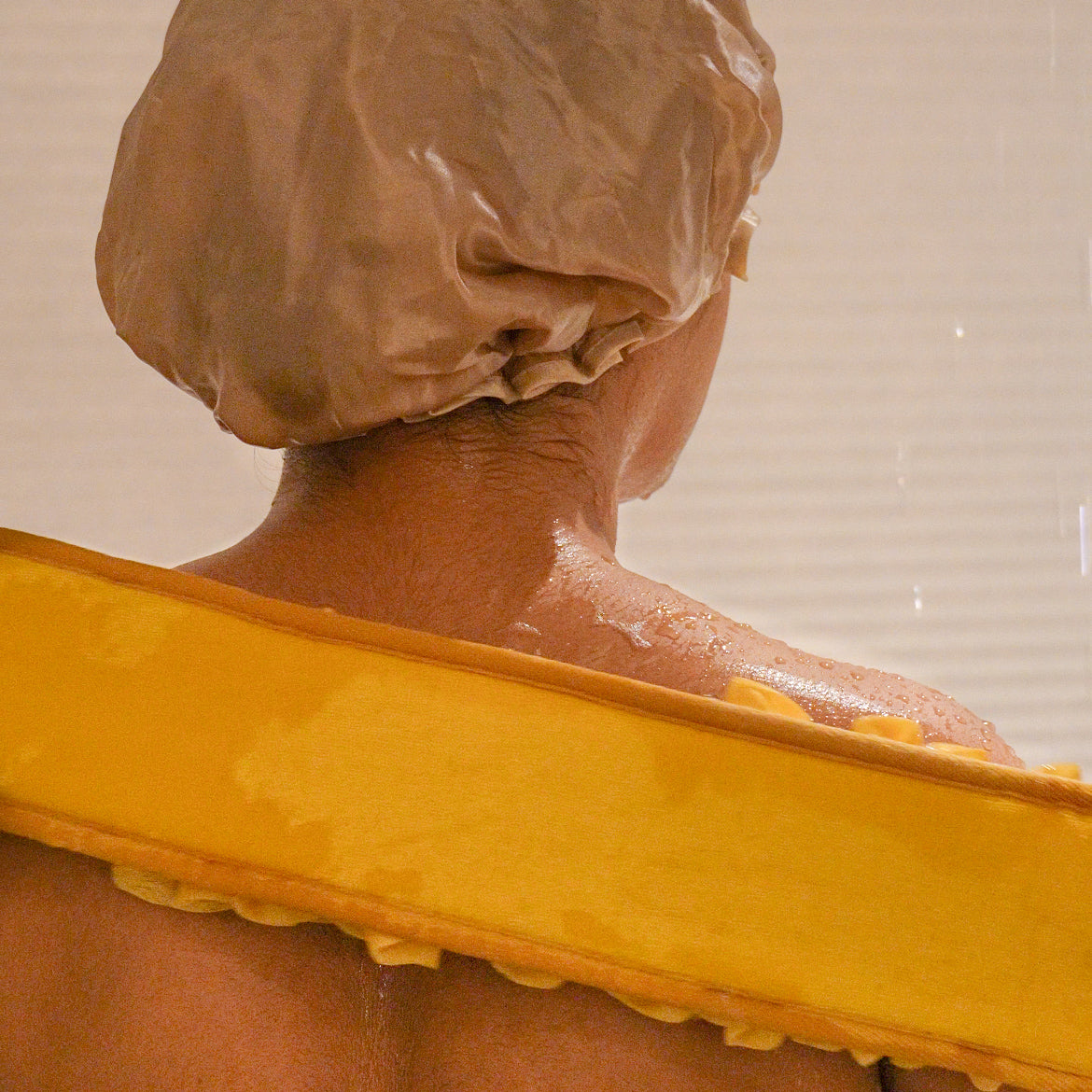 Woman using the yellow glow loop on her back.