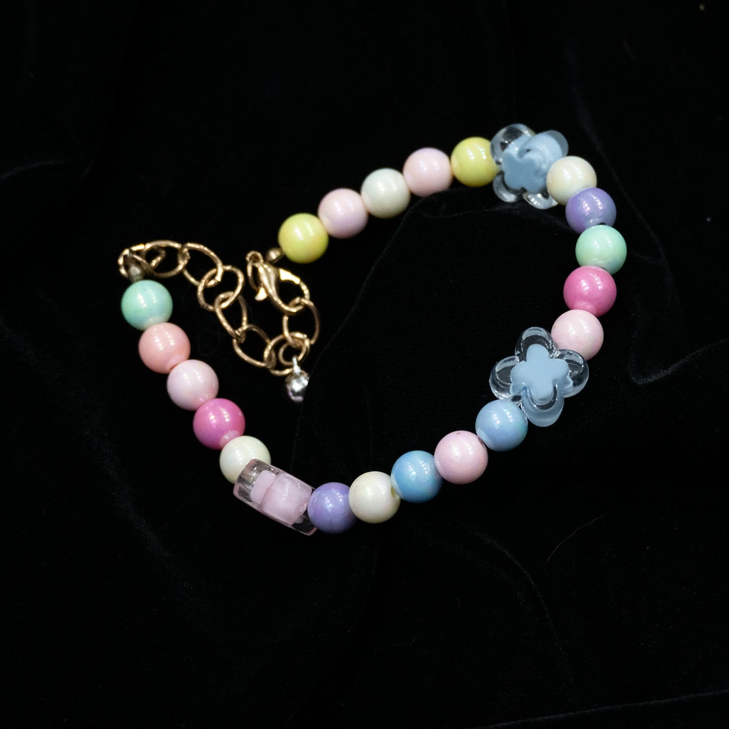 Multi-color beaded pet necklace laid out flat on a black background