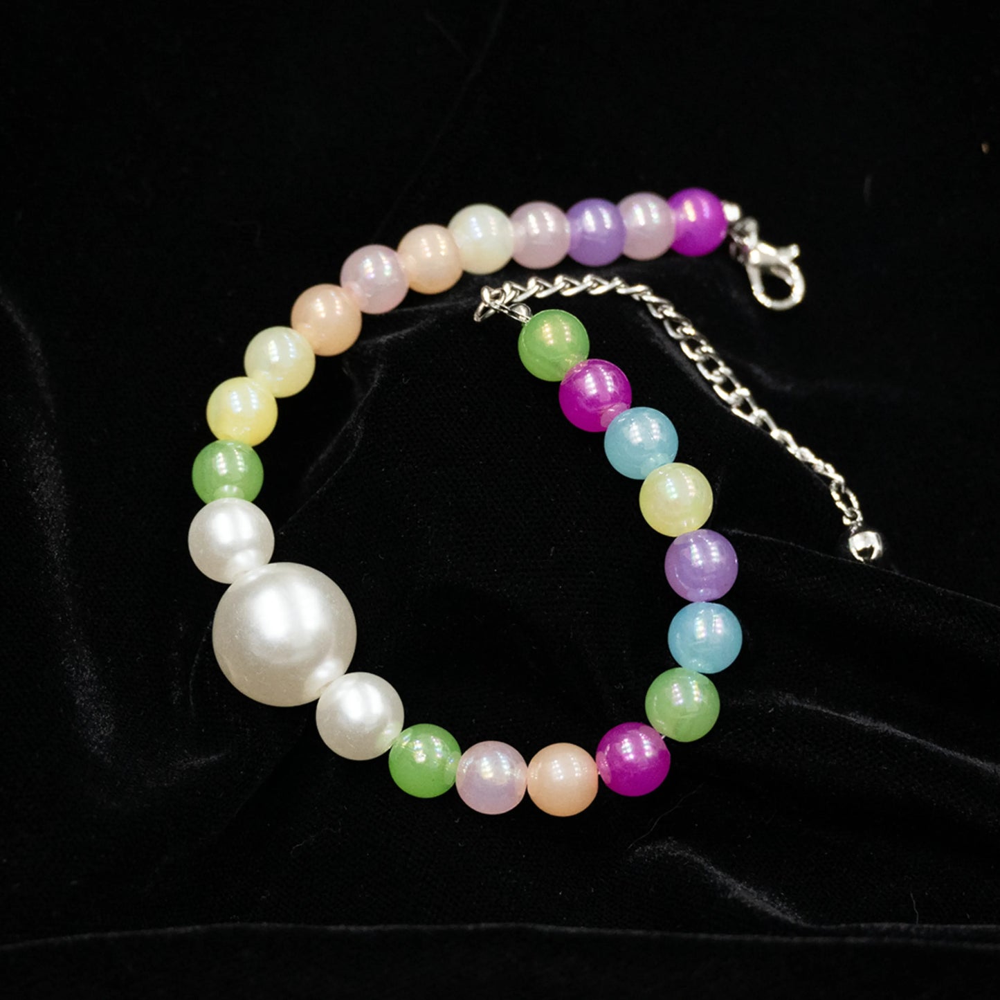 Multi-color pet necklace with pearl displayed on a black background