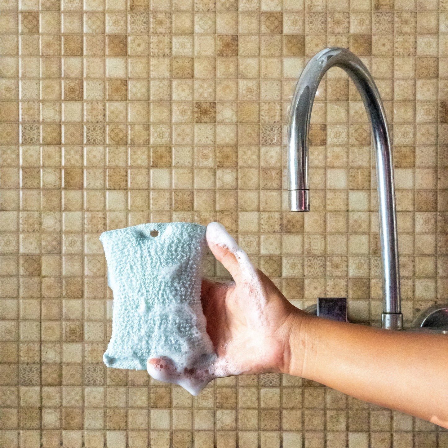 Person holding a compact blue oil wipe.