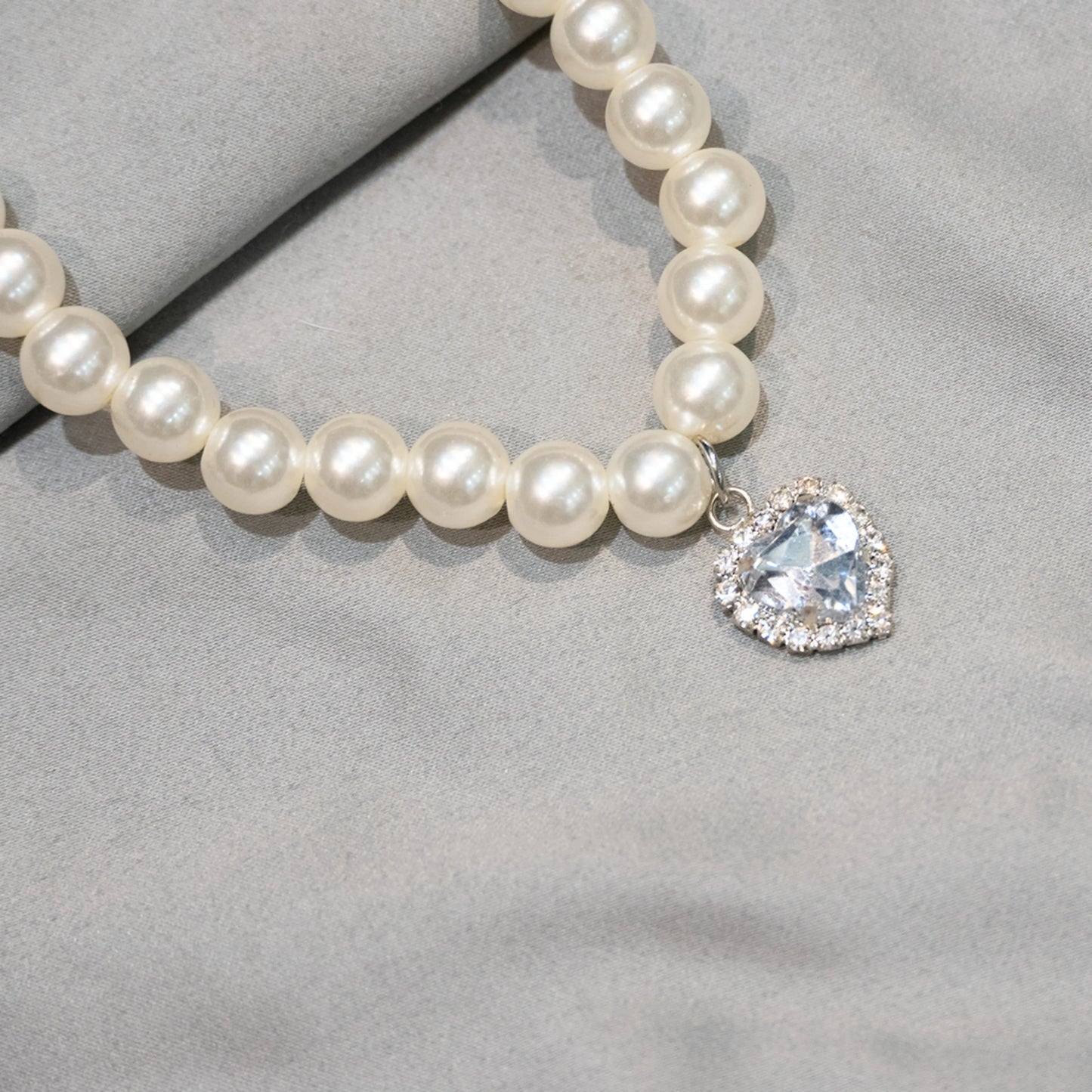 Close-up of white gemstone charm on grey background