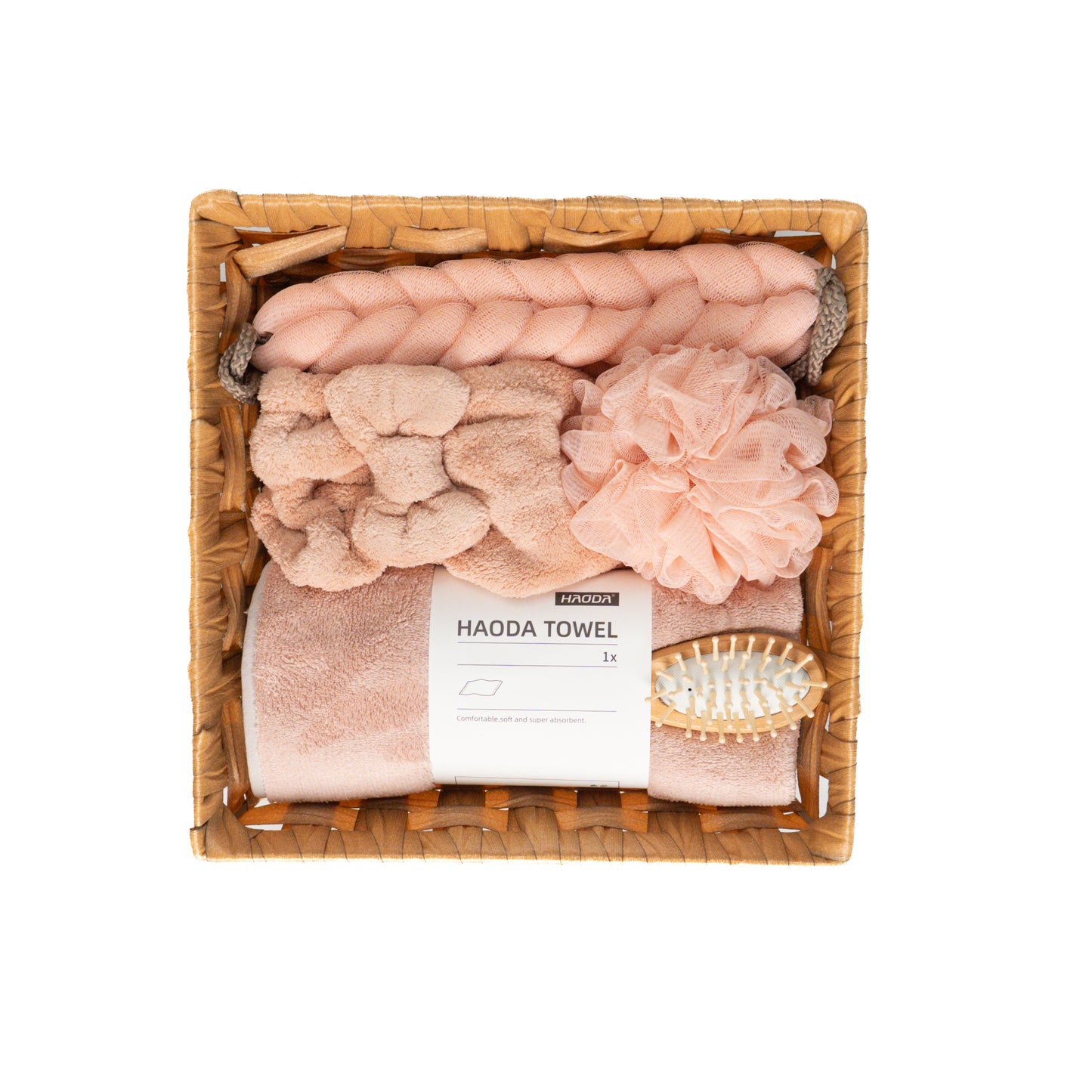Soothe Luxe pink shower kit neatly arranged in a rattan basket with towel, loofah, hairbrush, and headband