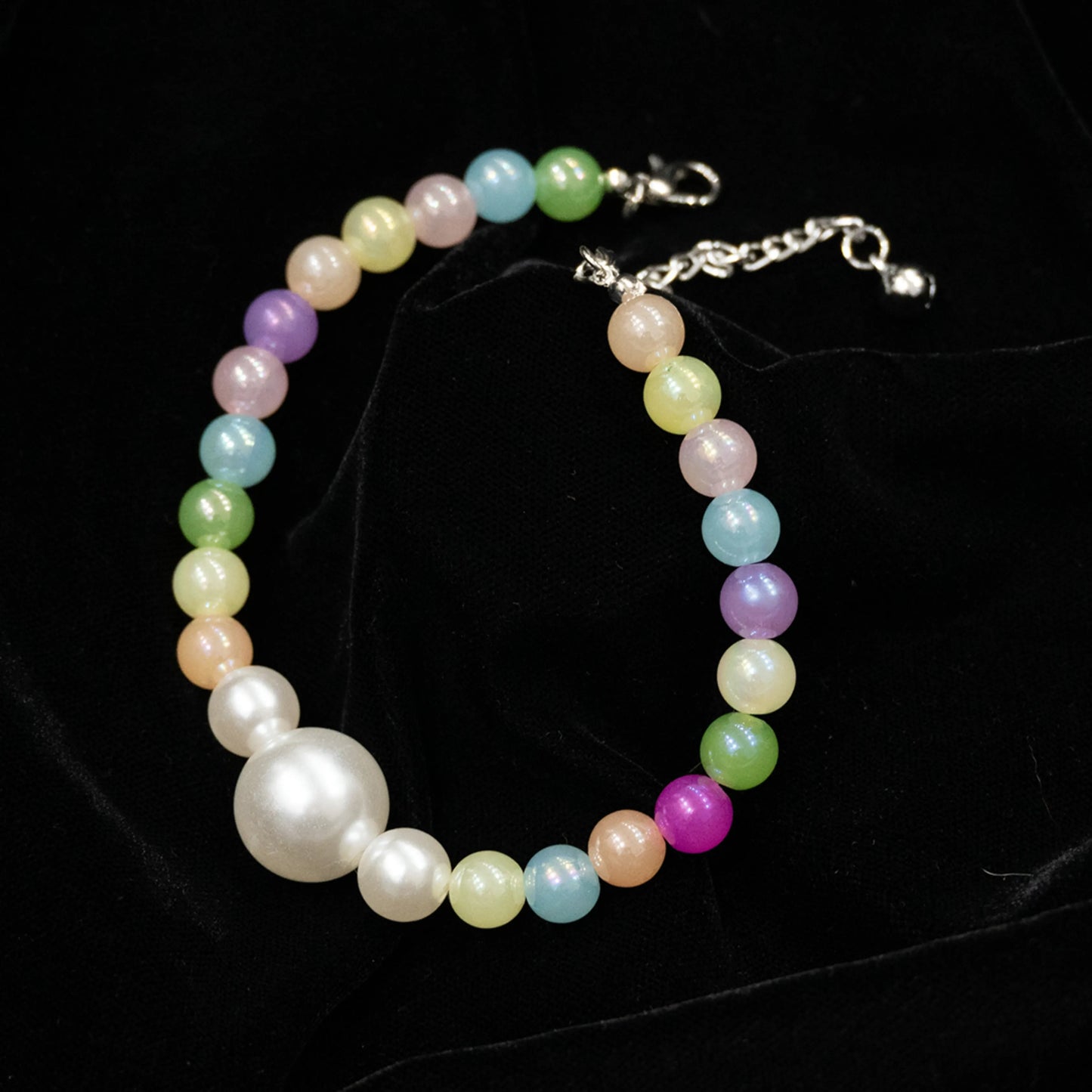 Multi-color pet necklace with pearl displayed on a black background
