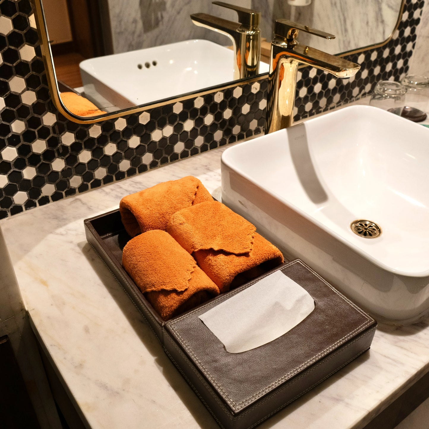 Bright orange Loom Touch towels arranged in a cozy bathroom setup