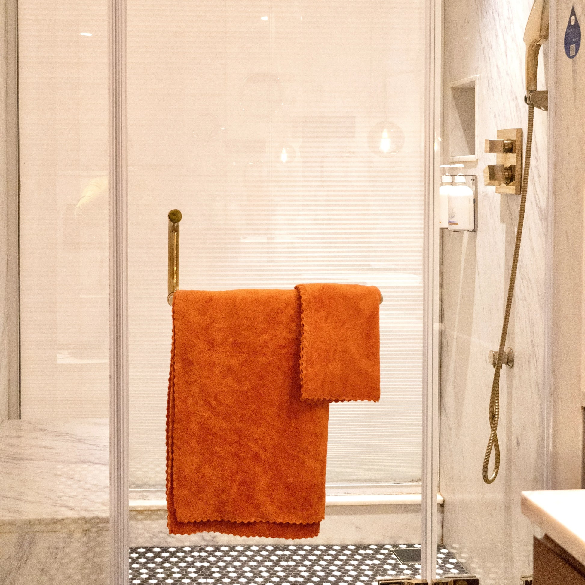 Soft Craze orange towel set arranged with bath accessories in a cozy setting