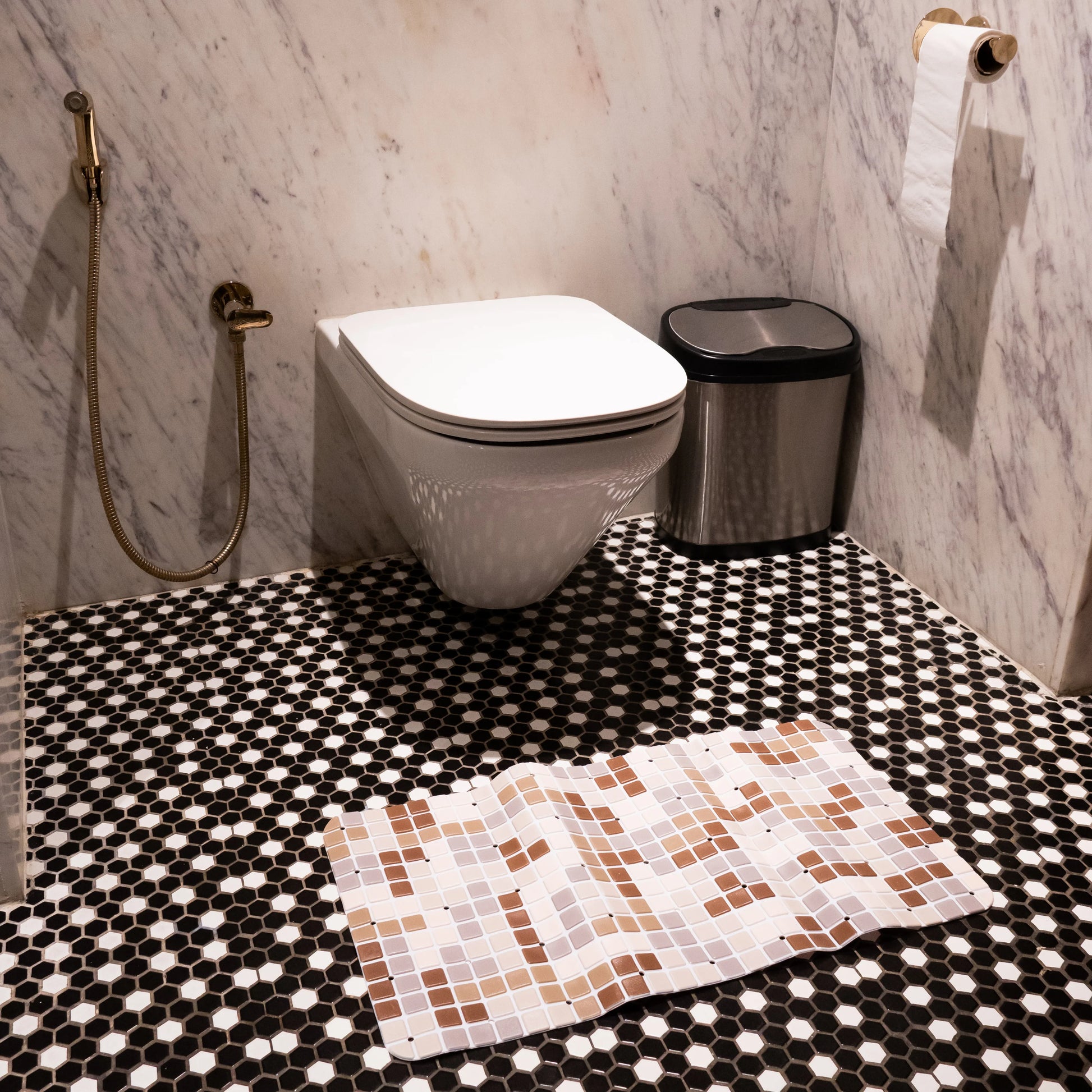 Brown-ivory mat placed in front of toilet.