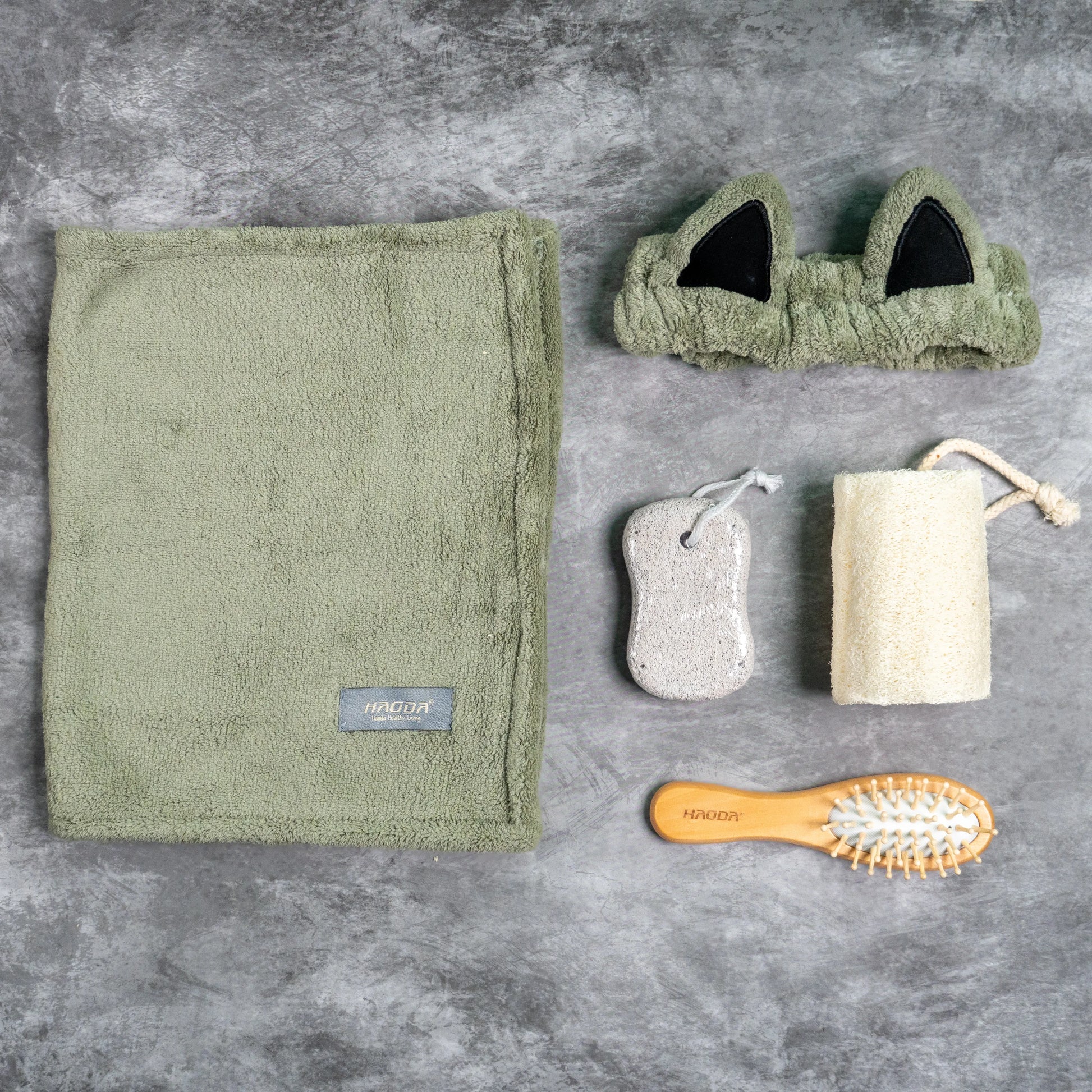 Olive green towel and headband set with wooden brush and bath tools.