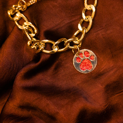 Close-up of glitter paw red pendant on gold chain collar
