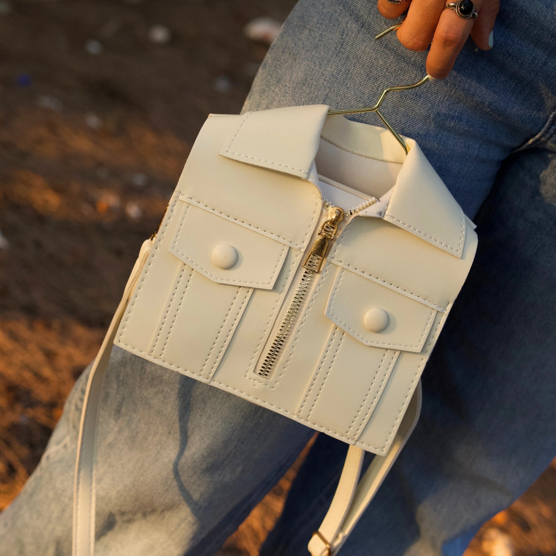 Woman holding the brown jacket-inspired handbag on outdoors setup