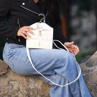 Woman placing the white jacket-inspired handbag on her lap