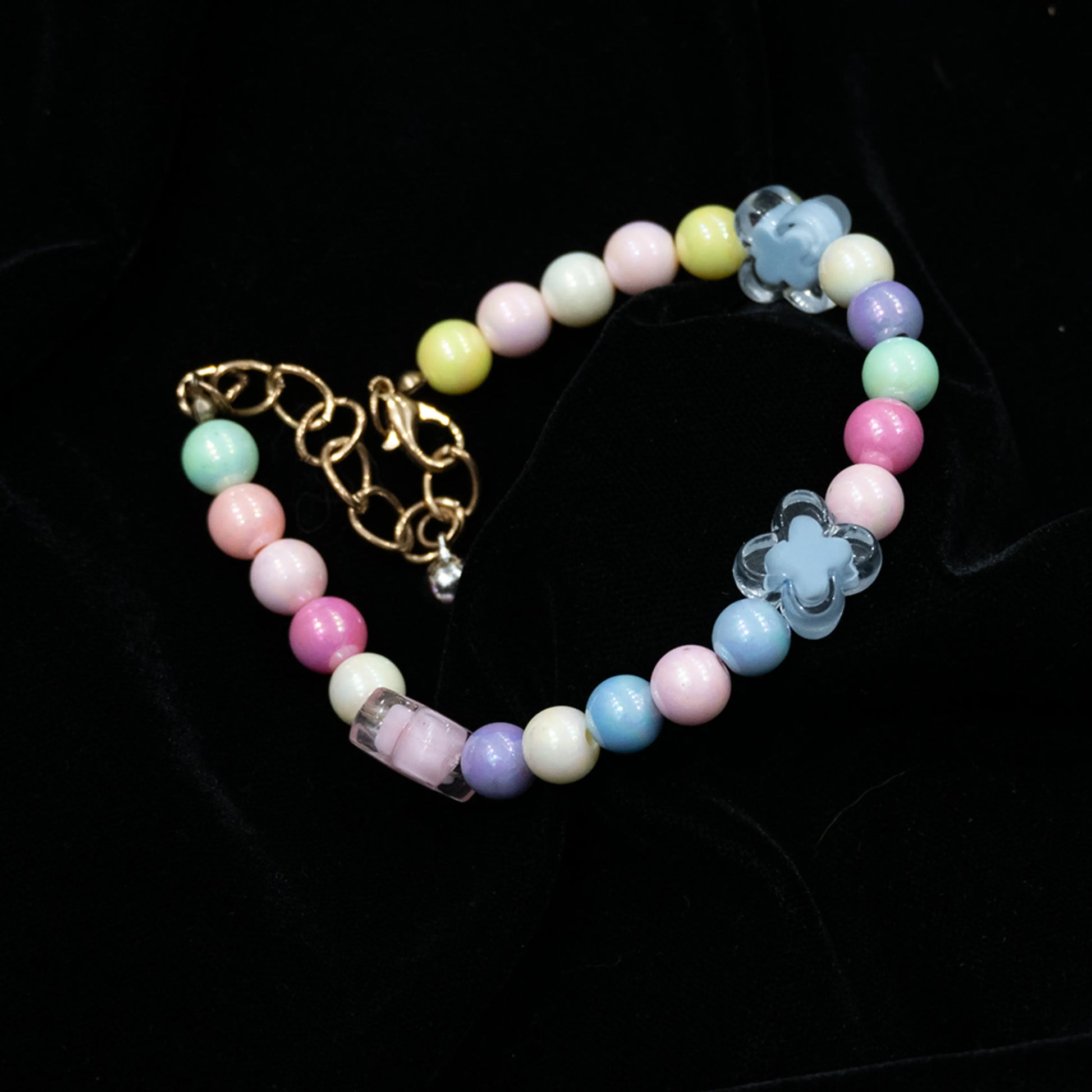 Multi-color beaded pet necklace laid out flat on a black background