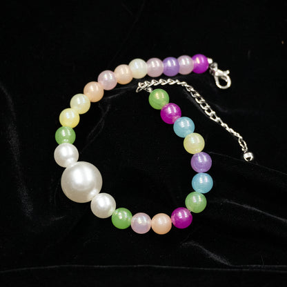 Multi-color pet necklace with pearl displayed on a black background