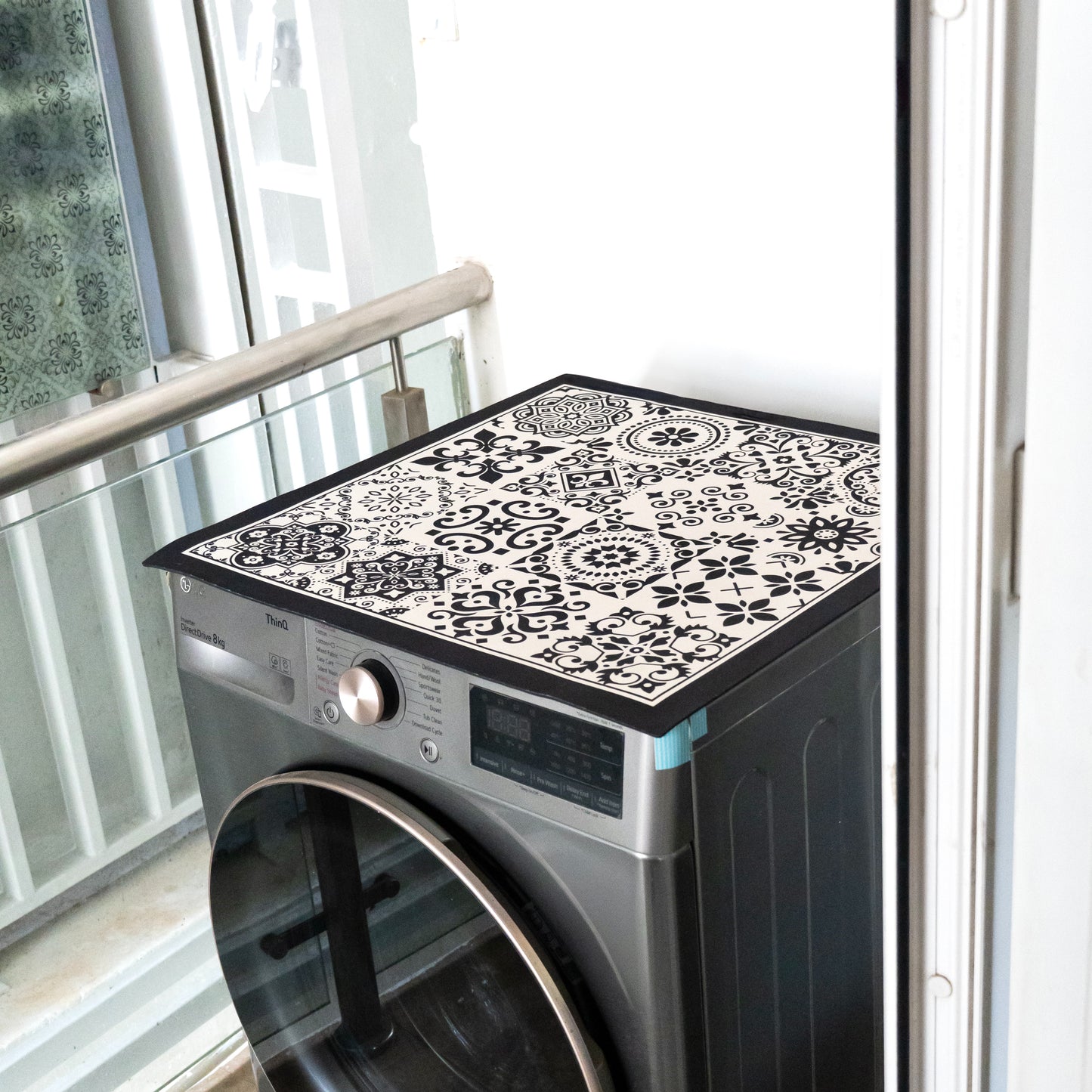 Black mat placed on top of washing machine.