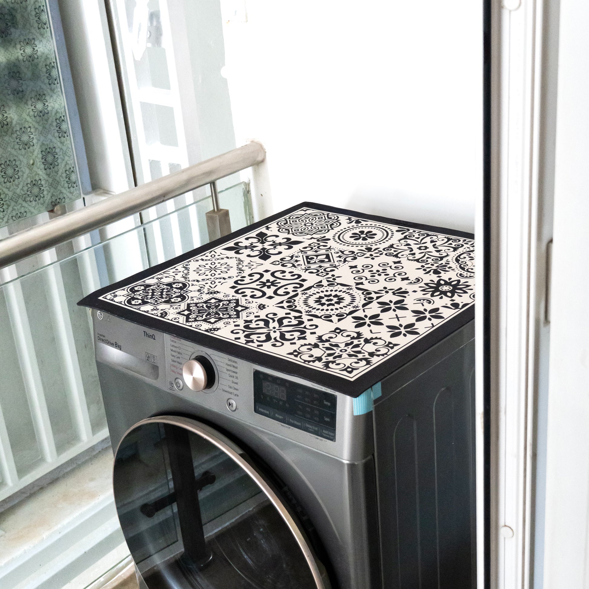 Black mat placed on top of washing machine.
