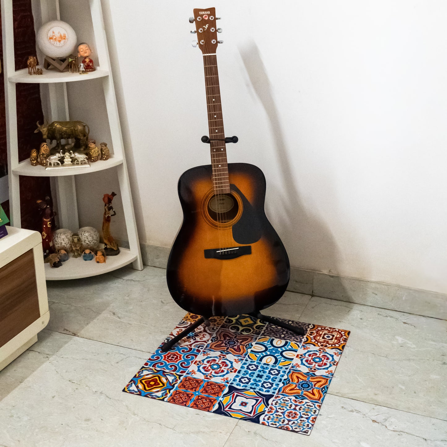 Multi-color mat on floor and guitar stand placed on top 