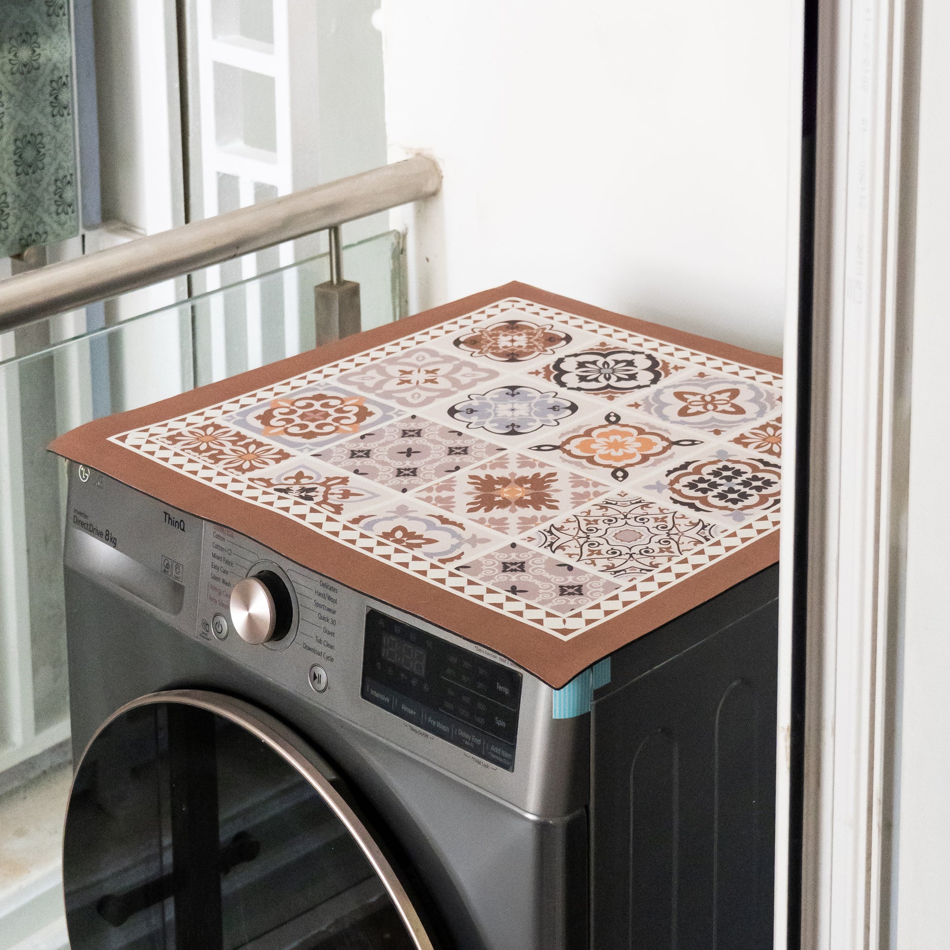 Beige mat placed on top of washing machine.