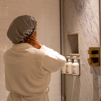 Woman wearing grey shower cap, head fully covered, angle 1.