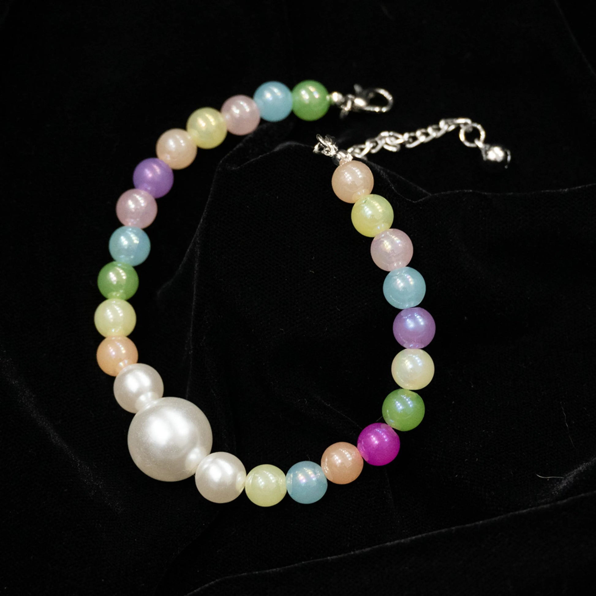 Multi-color pet necklace with pearl displayed on a black background
