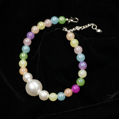 Multi-color pet necklace with pearl displayed on a black background