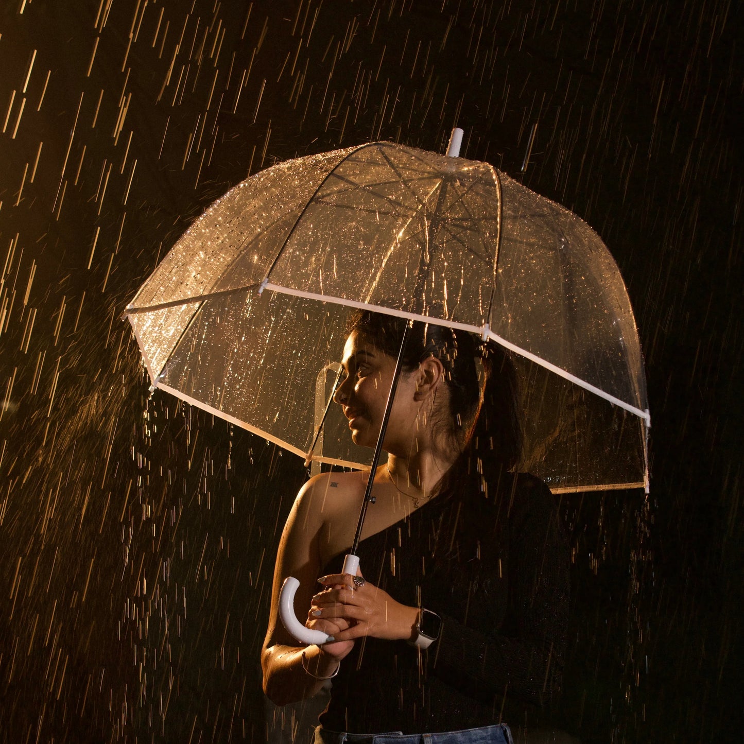 Close of woman walking with transparent umbrella under rain
