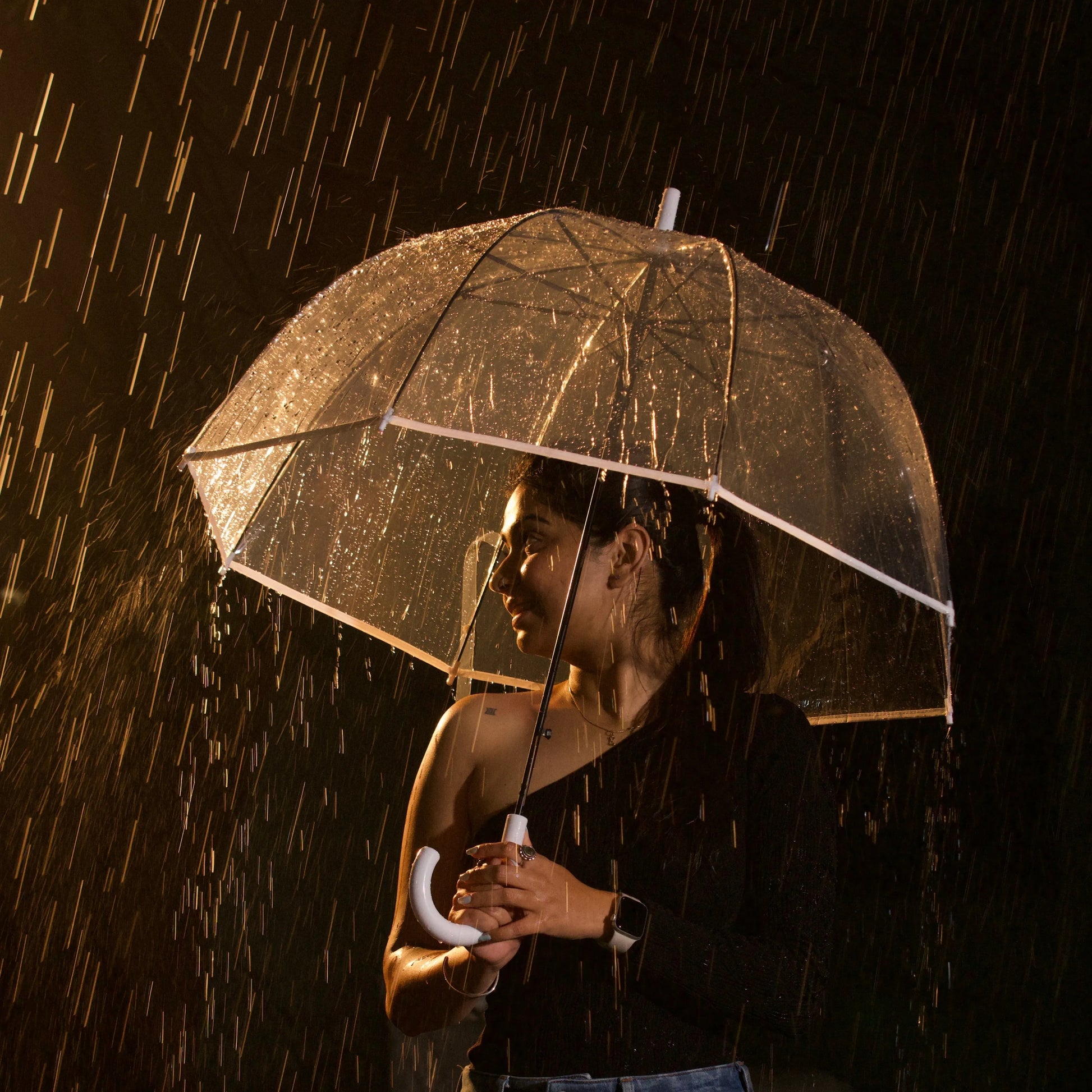 Close of woman walking with transparent umbrella under rain