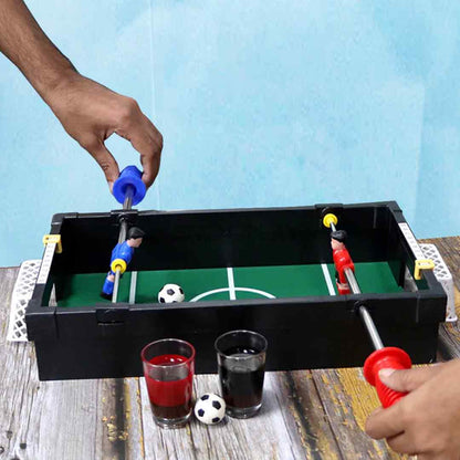 Unpacked foosball table setup with shot glasses and handles