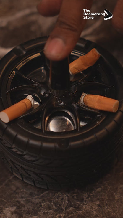 Wheel-shaped ashtray with push-and-spin lid, cigarette resting on rim.