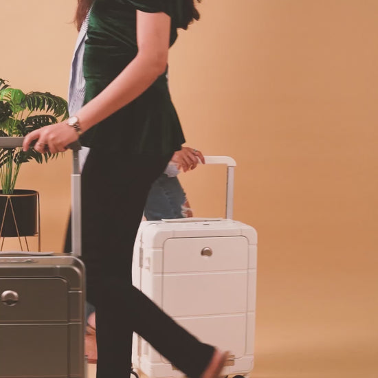 Suitcase with front open compartment, cup holder, built-in USB charging port, and smooth wheels.