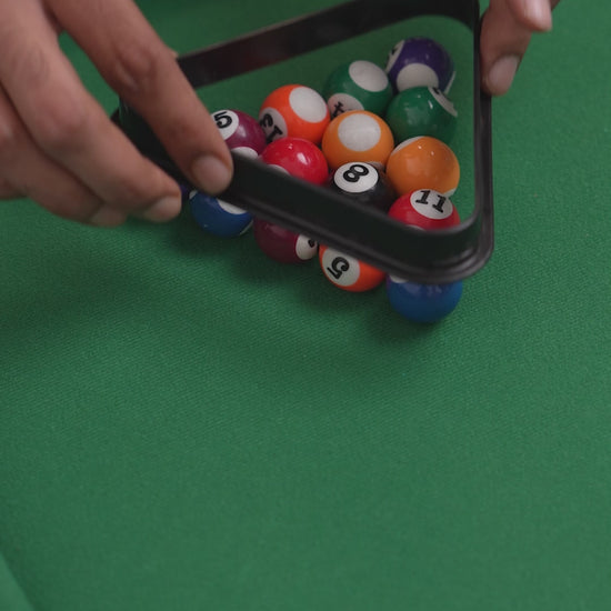 Miniature pool table with cues, balls, and green felt surface.