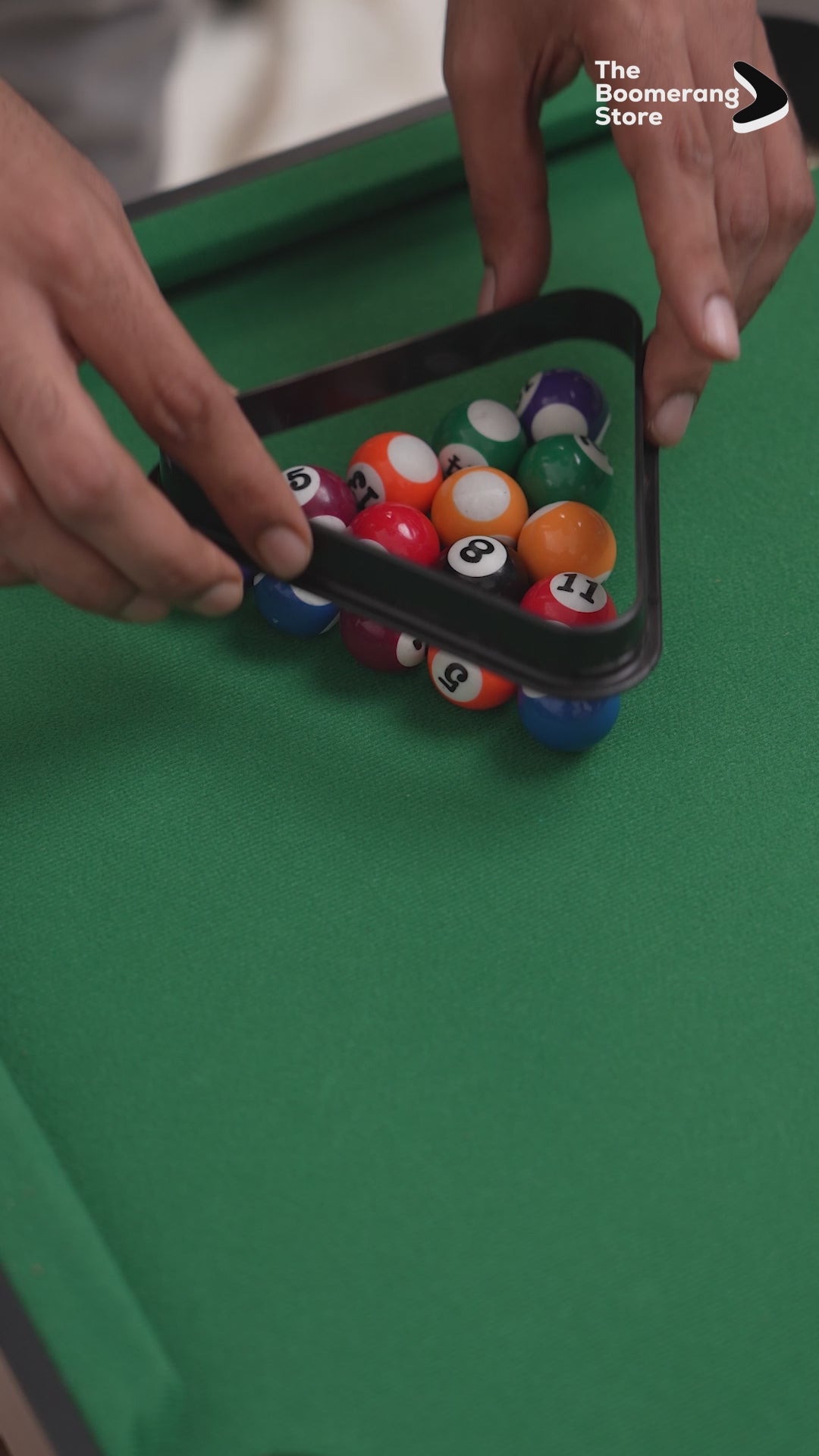 Miniature pool table with cues, balls, and green felt surface.